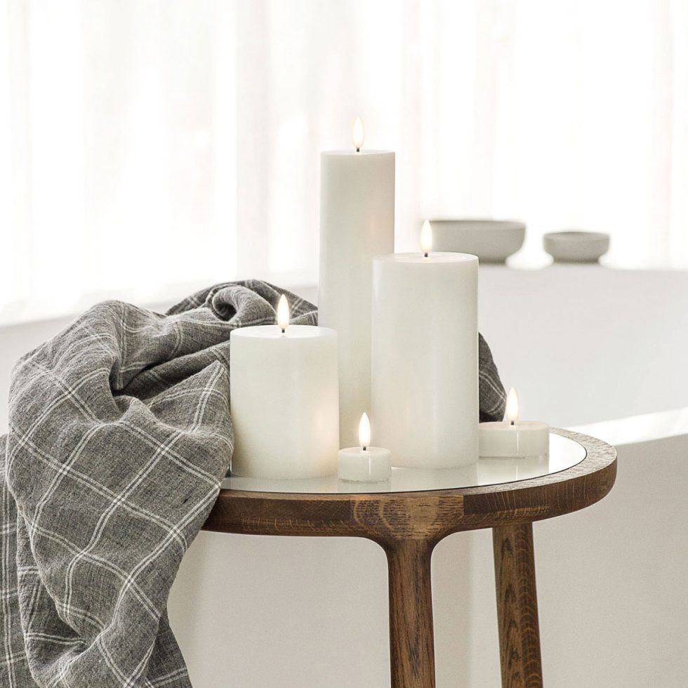 Warm Scandi minimalist styling featuring Uyuni Lighting Classic Ivory Flameless Pillar Candles and Tea Lights on an EKTA Holmes coffee table, creating a calm and inviting living space.