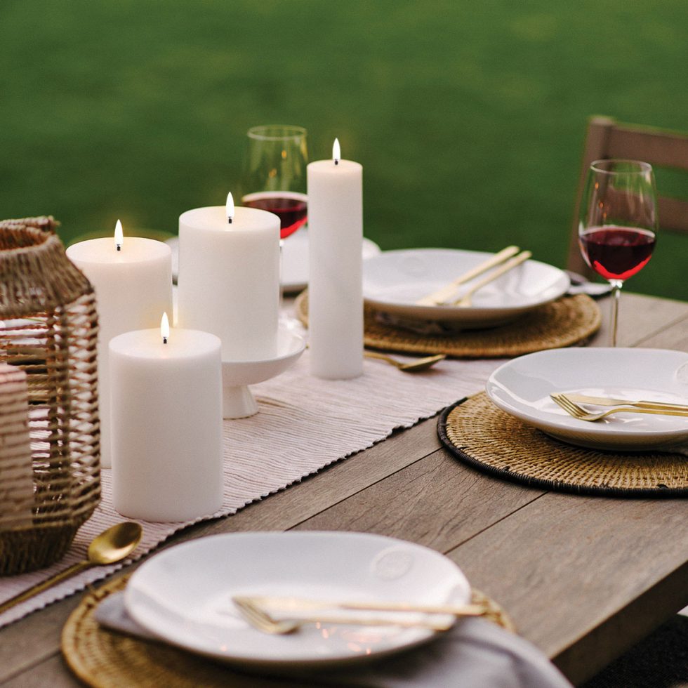 Outdoor dining table styling with Uyuni Lighting Classic Ivory Flameless Pillar Candles, creating an elegant centrepiece for alfresco entertaining.